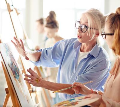 2 girls looking at paintings