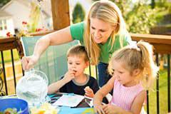 woman pouring drink for boy and girl