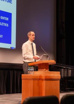 Dane Roberts, first place winner of the essay contest in the Graduate category, reads his winning essay in the auditorium of the JSB