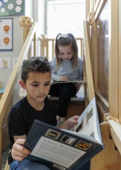 Two kids reading on a staircase