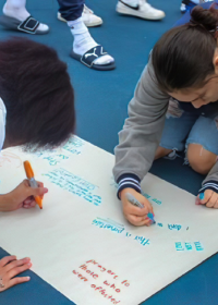 Girls writing on a poster